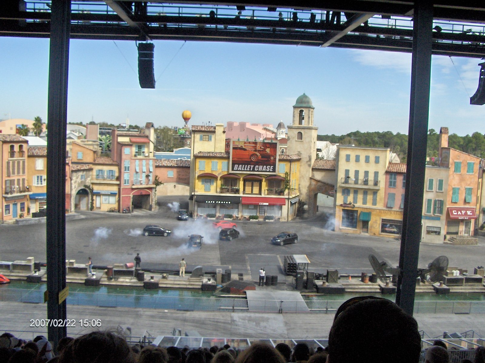 Arena de show de dublês do Lights Motors Action com cenário de vila francesa e carros pretos e vermelho em cena, vista da arquibancada