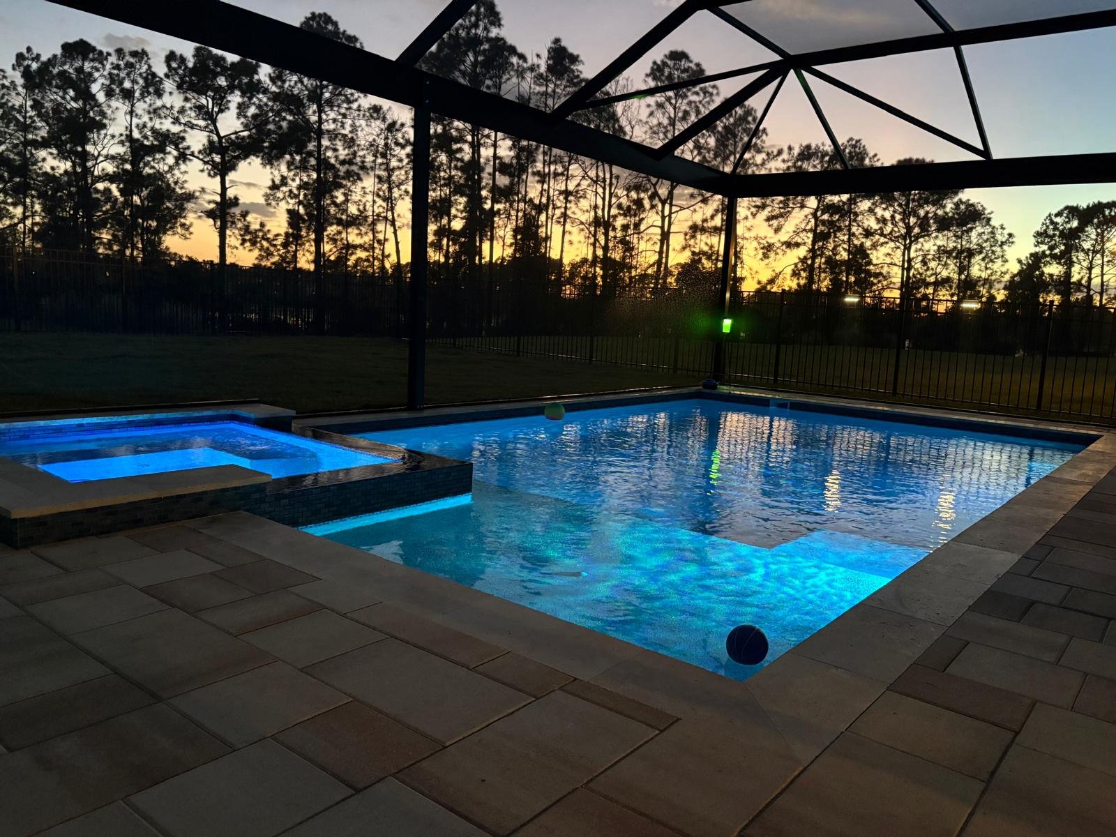 Piscina com screen enclosure em casa de temporada de Kissimmee ao entardecer, uma das opções de hospedagem para famílias brasileiras que visitam a Disney