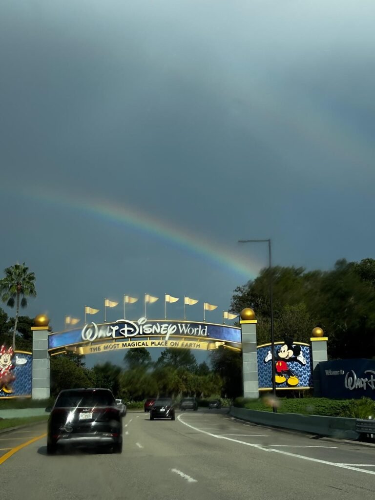 Portal de entrada do Walt Disney World sob chuva e arco-íris, exemplo do clima variável de Orlando